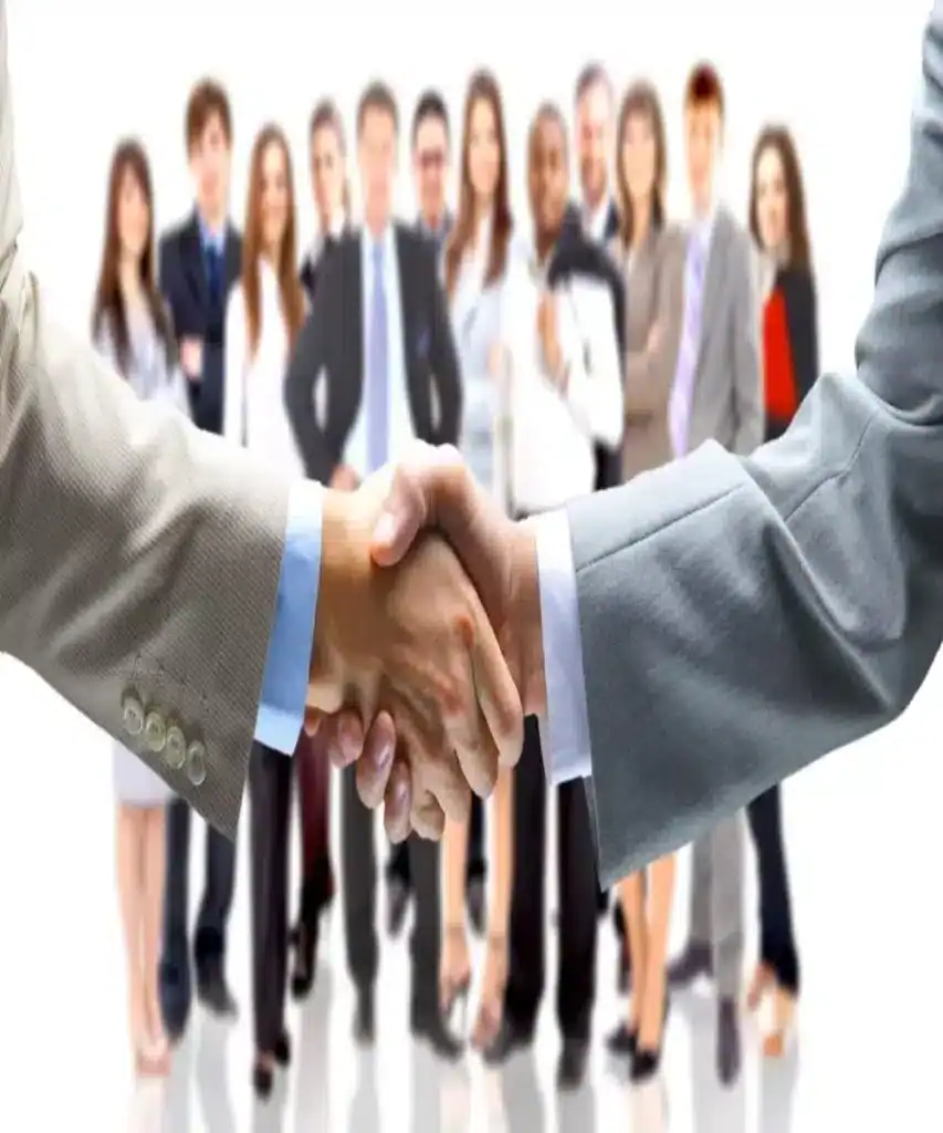 Wymiana ręki w uścisku podczas spotkania biznesowego z grupą profesjonalistów w tle, symbol partnerstwa i współpracy, dla stron biznesowych i firm, Global Stone, kamień naturalny, wykończenia wnętrz, reprezentacja jakości.